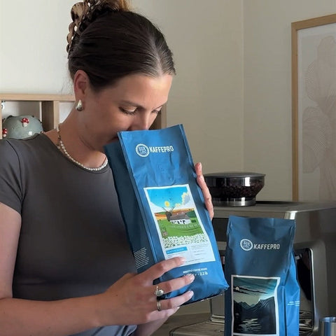 Ein Kunde riecht an einem Beutel Kaffepro Morning Bloom