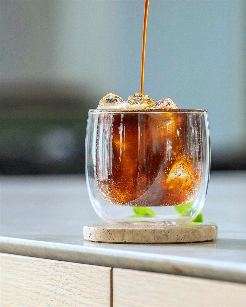 Espresso Tonic: Espresso läuft über Eis in ein doppelwandiges Glas