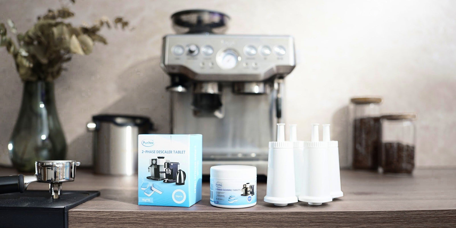 Eine Espressomaschine mit Pure-Wave-Wasserfiltern, Puritex Reinigungs- und Entkalkungstabletten, einem Siebträger auf der Tampermatte und Kaffeebohnen im Glas