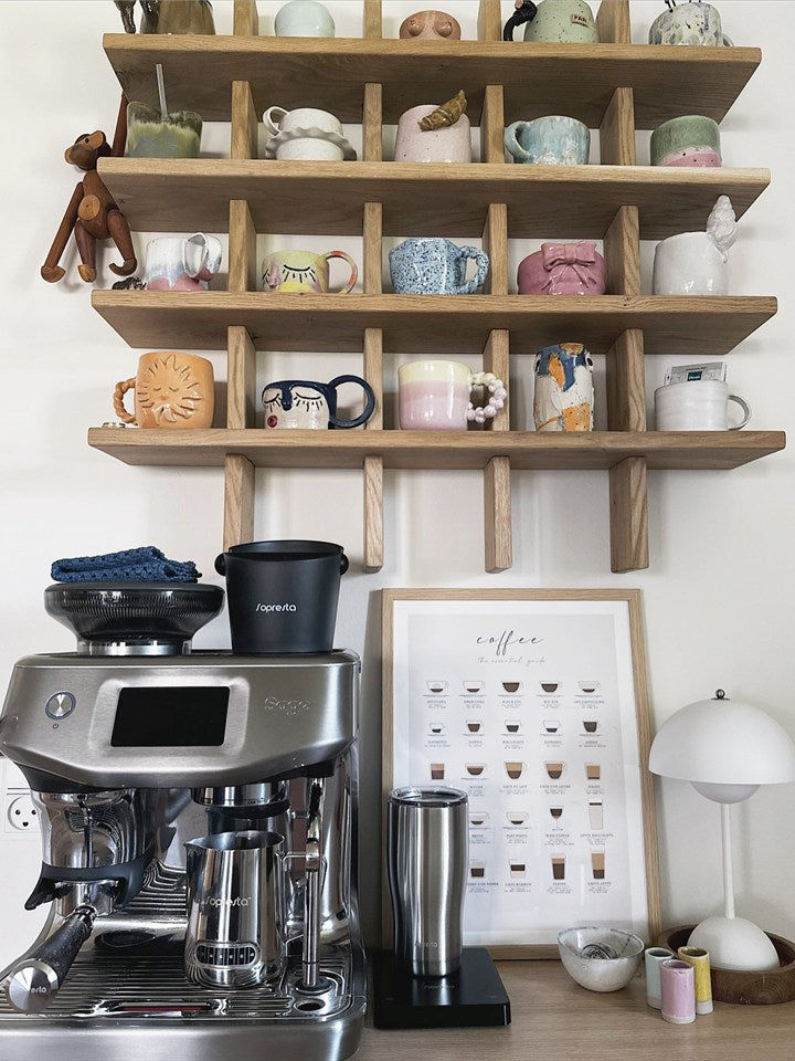Eine Kaffee-Ecke mit einer Sage-Espressomaschine unter Regalen mit Tassen